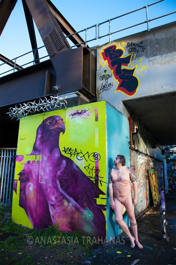 man leaning on wall by graffiti