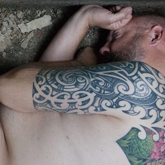 person curled up, tattoo, naked man