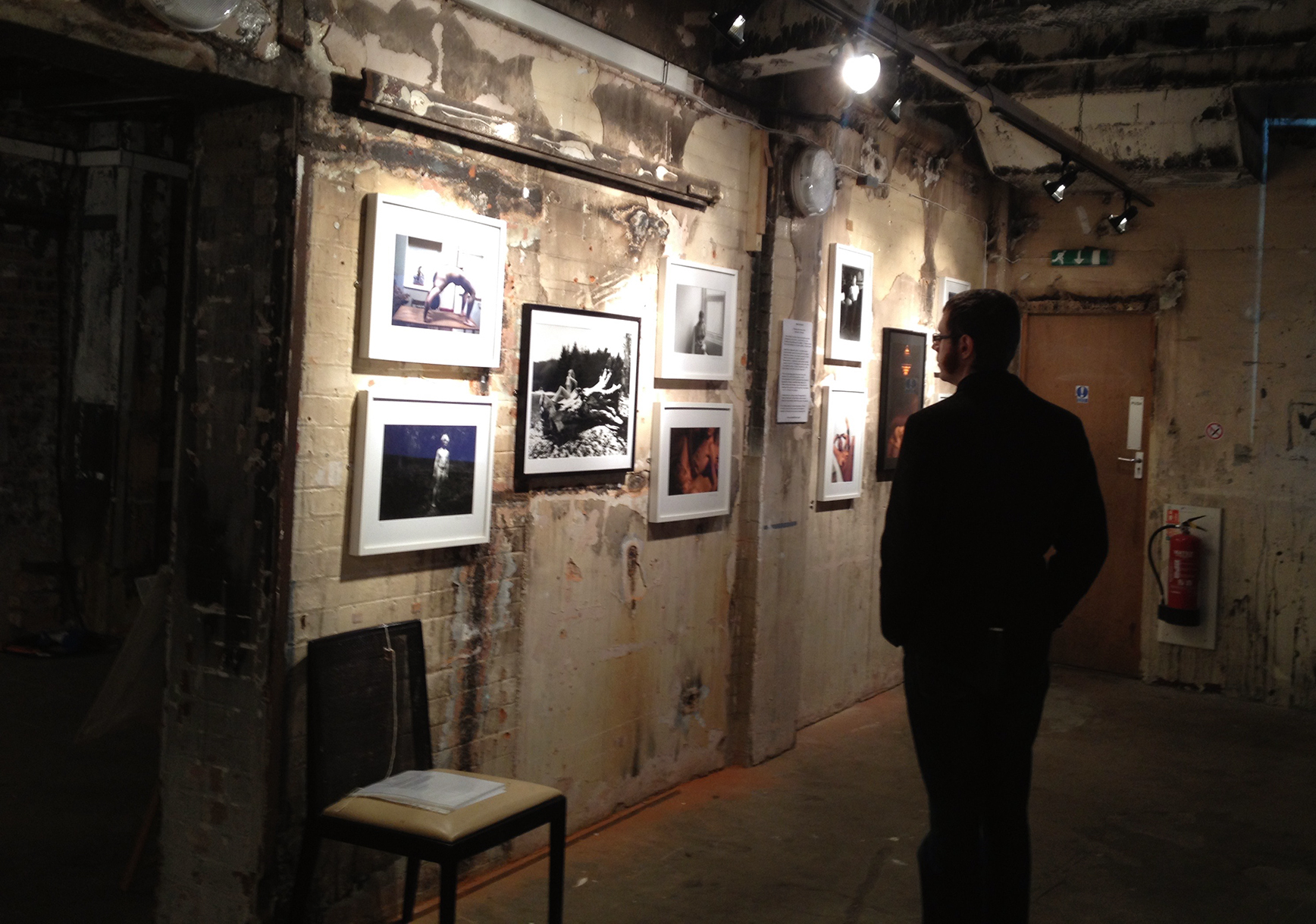 Maverick Expo man, indoors, viewing photographs of naked Britain exhibition