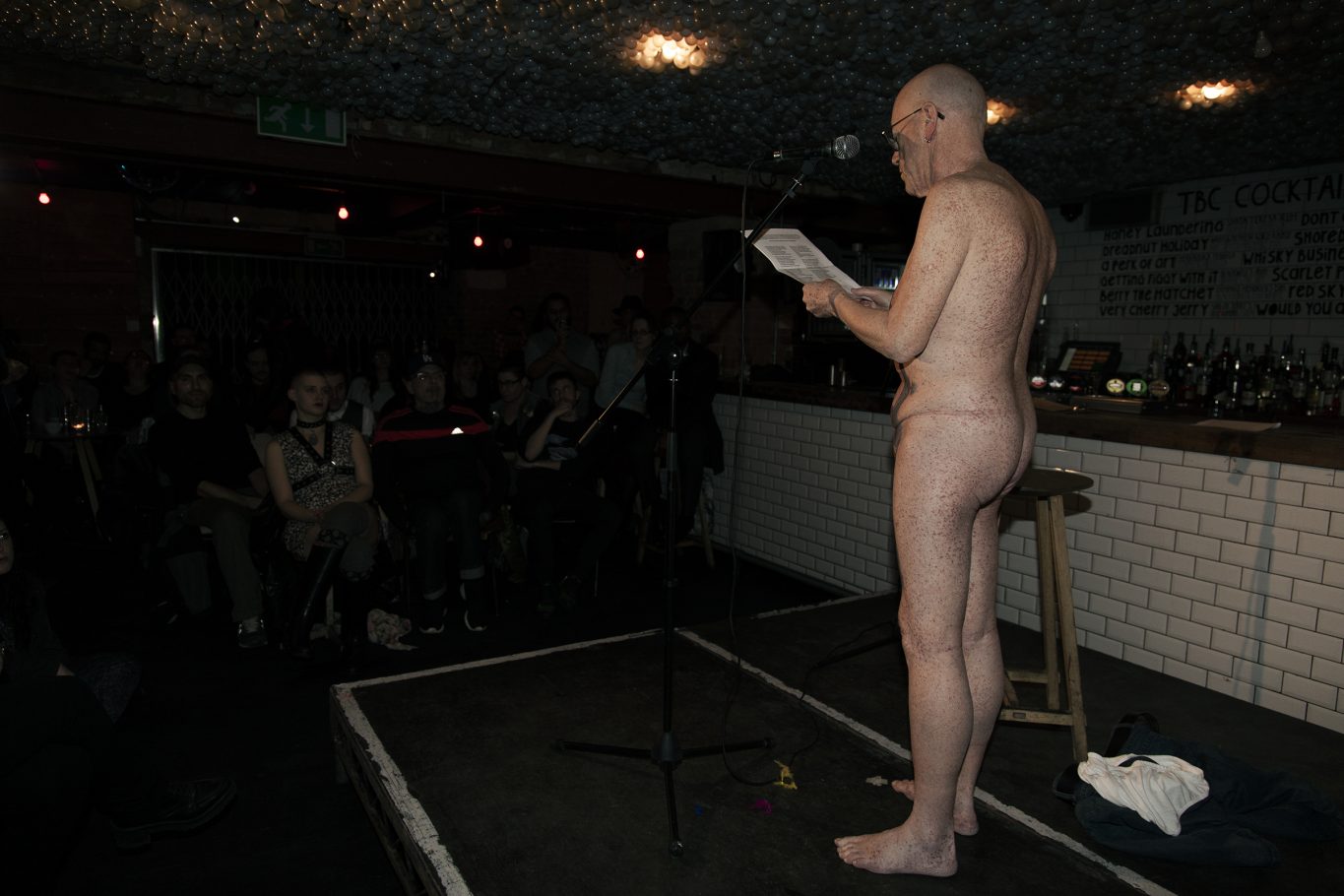 naked person on stage, audience, indoor