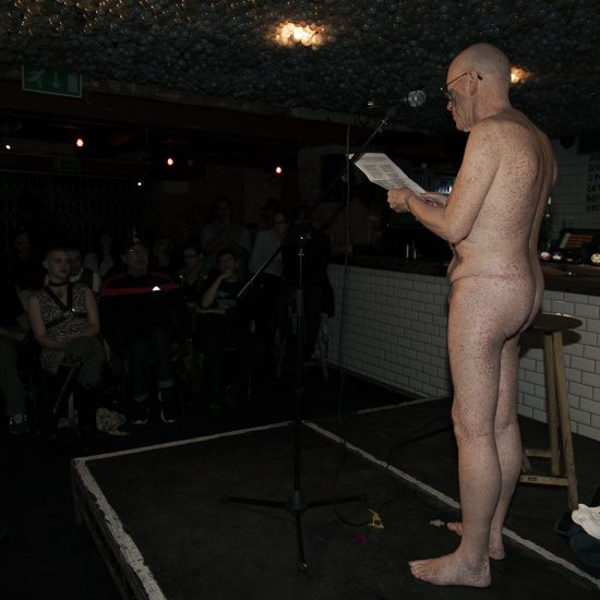 naked person on stage, audience, indoor