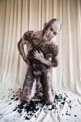 naked man covered in mud looking vulnerable